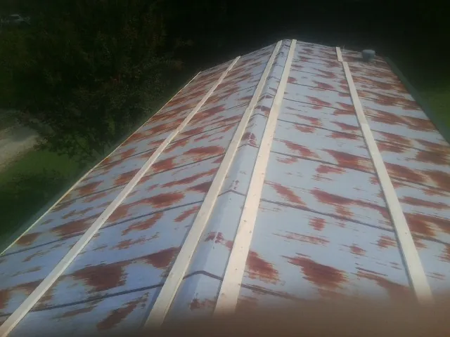 Rusted metal roof panels with new wood purlins before replacement — Storm Damage Roof Repair in Chicago Ridge by Roofing Brothers