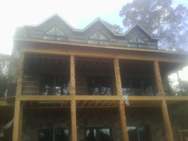 Dormers and porch framing on a large log home under construction — Roof Coating work by our crew in Chicago Ridge