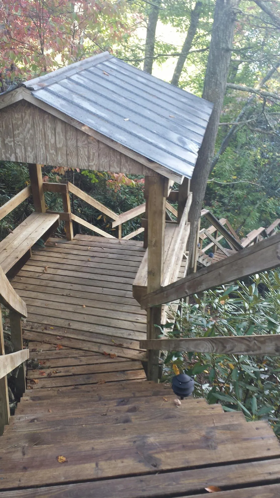 Metal roofed shelter over wooden steps on a wooded walkway — Skylight Repair & Installation work by our crew in Chicago Ridge