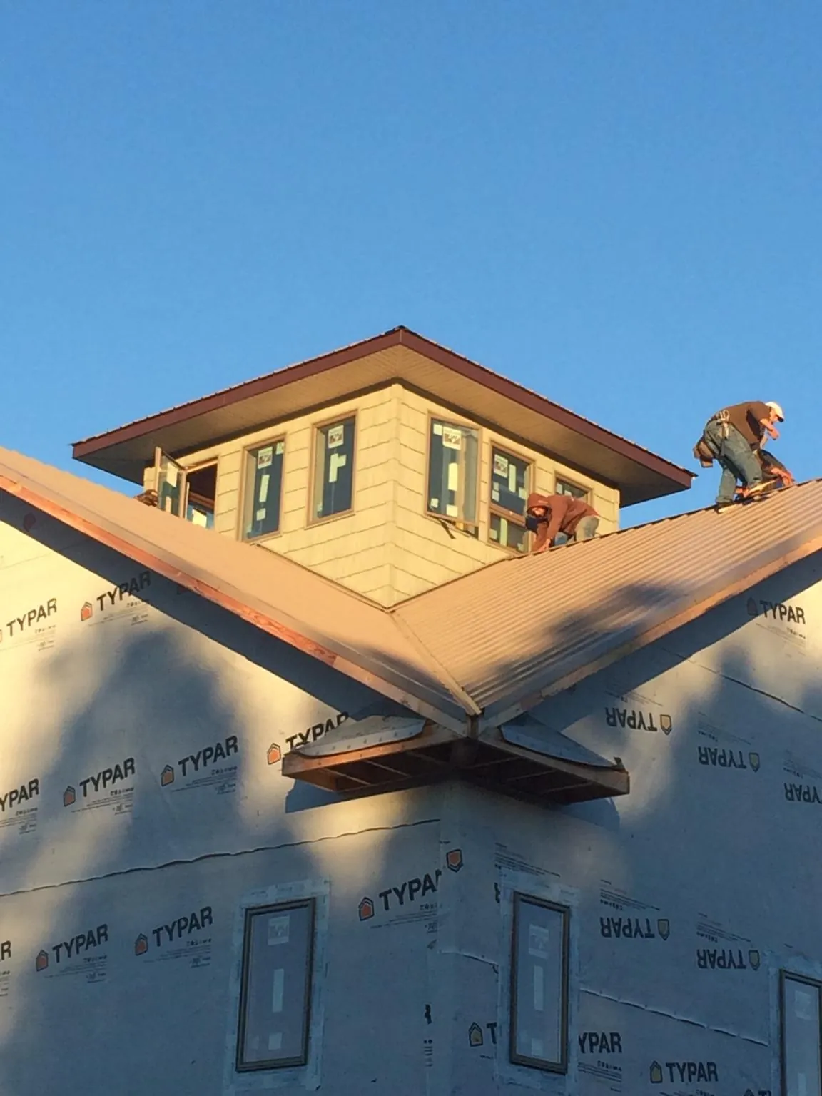 Roofers working around a rooftop cupola on a new metal roof at sunset — Roof Waterproofing in Chicago Ridge by Roofing Brothers